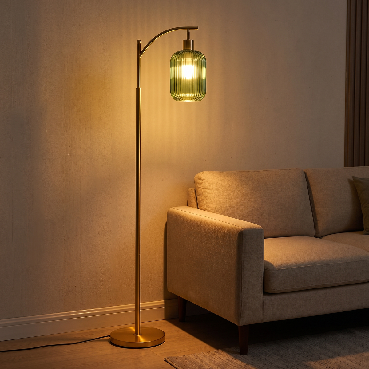 Gold floor lamp with green glass shade beside a sofa