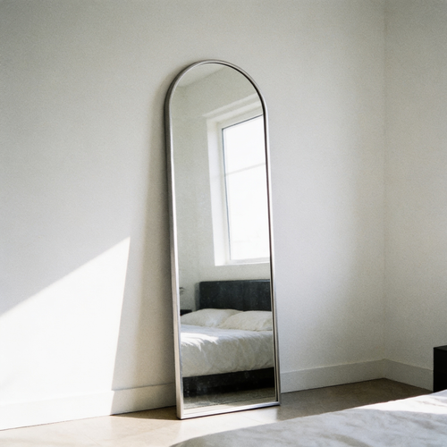 Arched aluminium framed mirror in a plain modern bedroom
