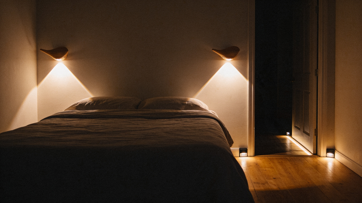 Bedroom lit by dimmed sconces and floor lights