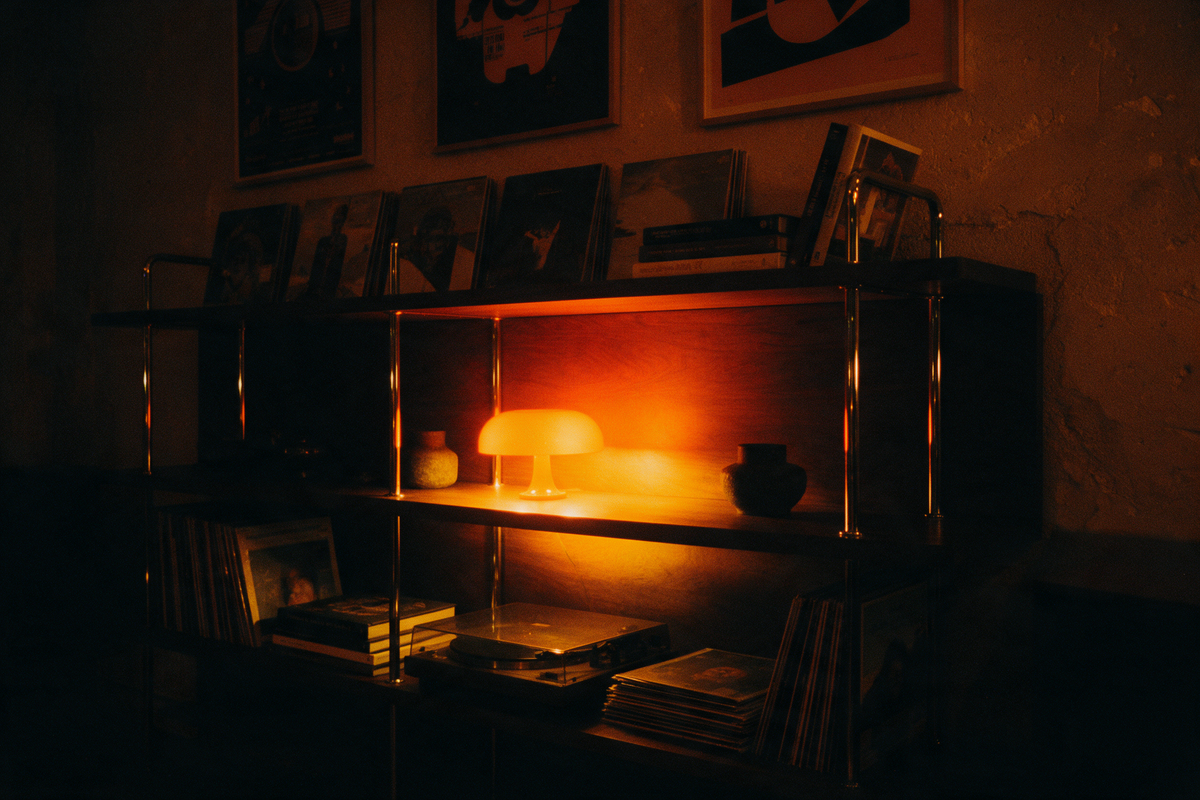 Shelving with a turntable, vinyl and a glowing dome lamp at night